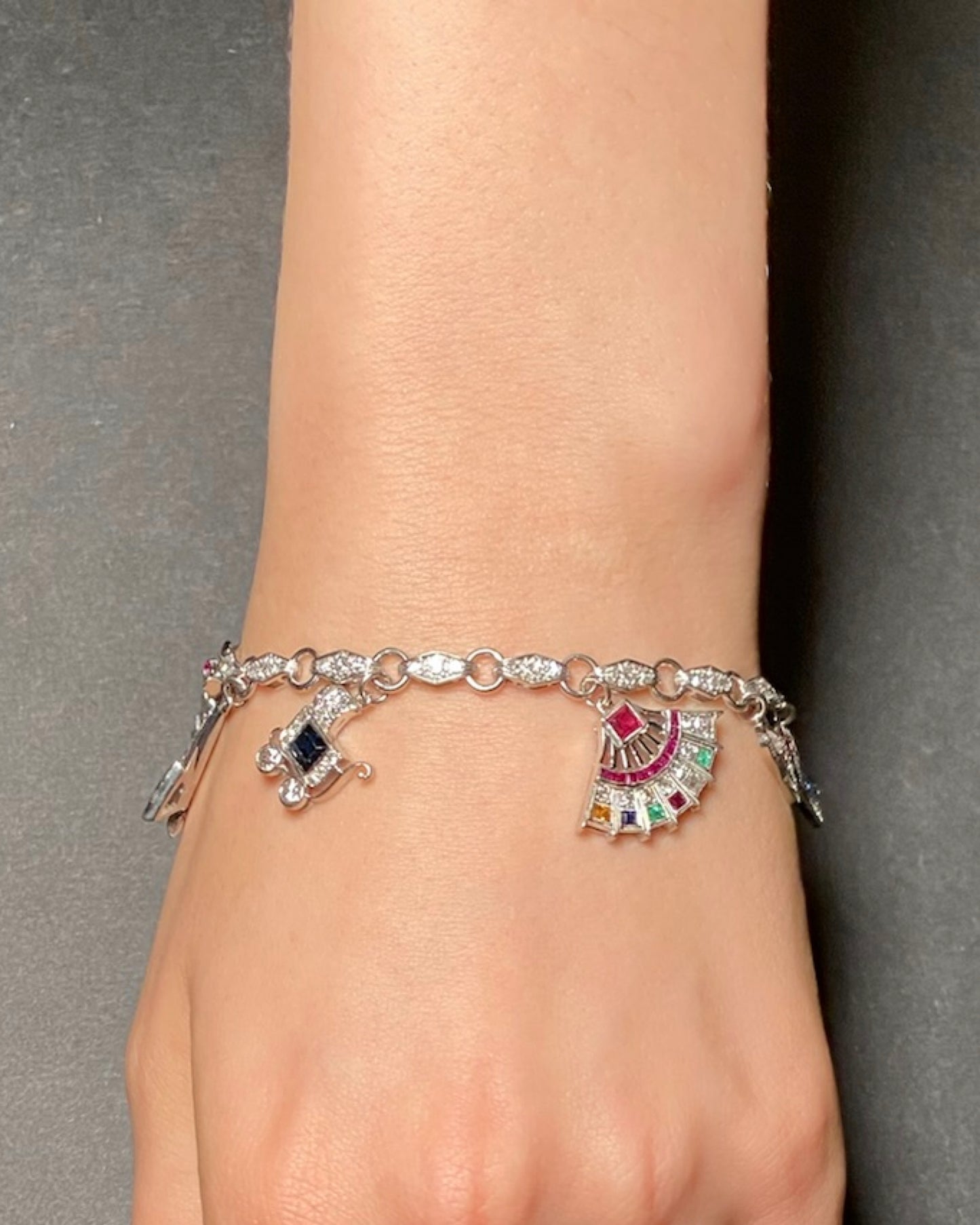 ART DÉCO DIAMOND, COLOURED GEMSTONES & PLATINUM BRACELET WITH 12 CHARMS, INCL. 1 BY CARTIER