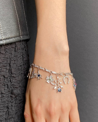 ART DÉCO DIAMOND, COLOURED GEMSTONES & PLATINUM BRACELET WITH 12 CHARMS, INCL. 1 BY CARTIER