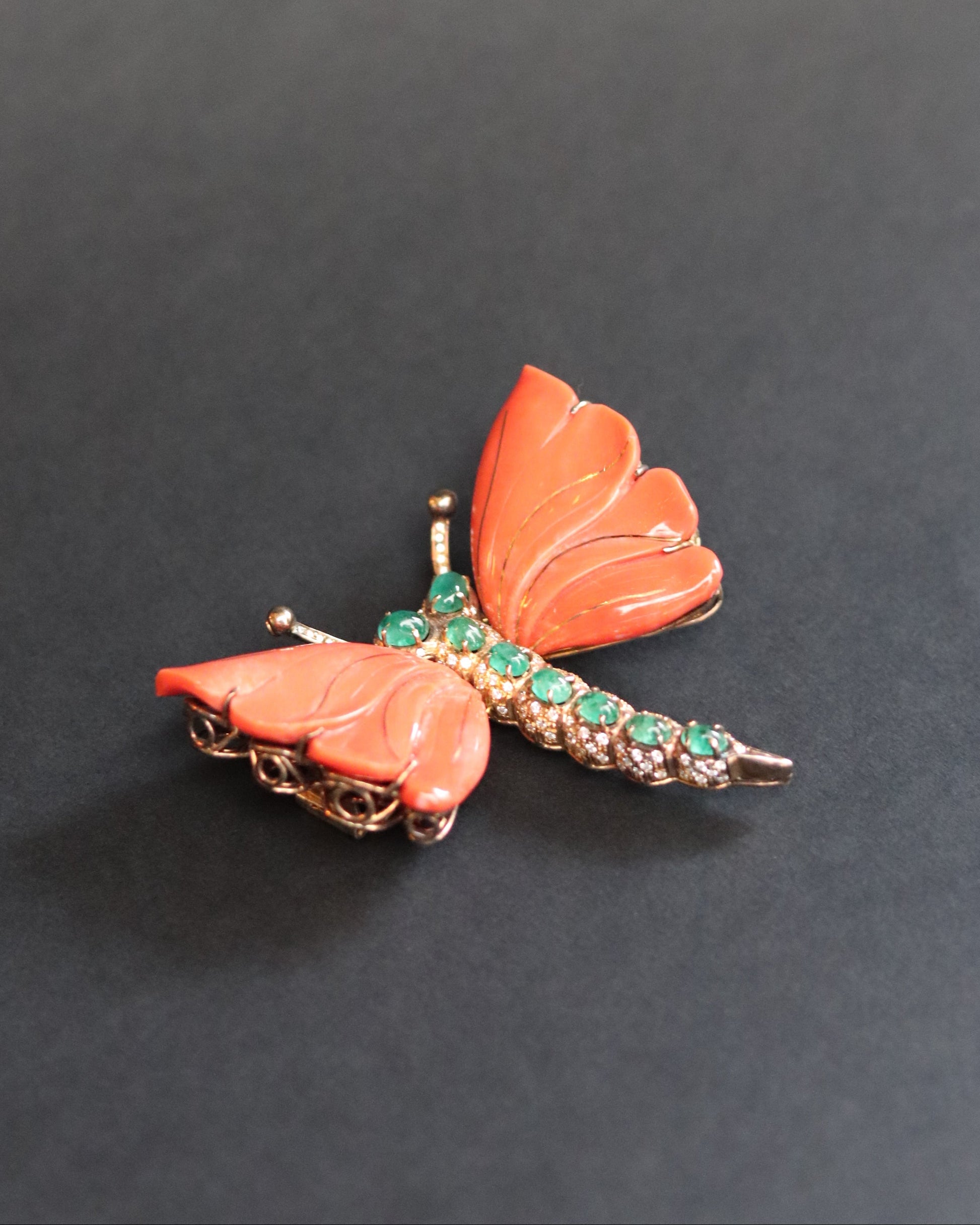 A MONUMENTAL ITALIAN BUTTERFLY BROOCH with eight cabochon emeralds and diamonds over coral